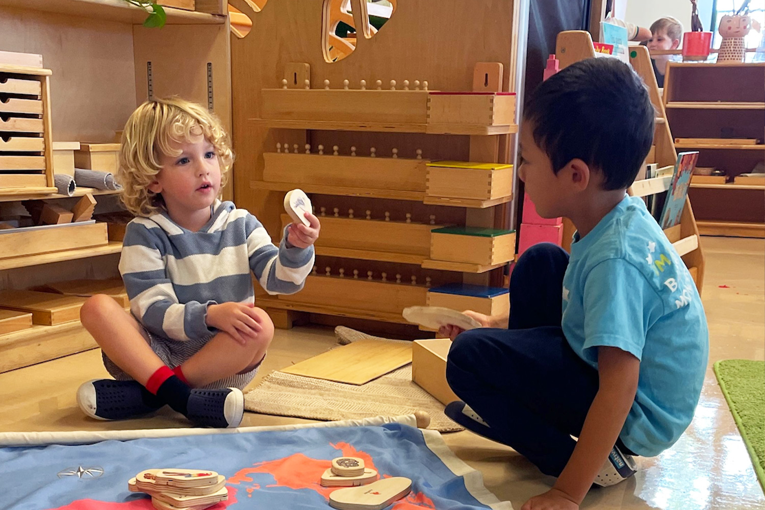 Two students in the mixed age Casa class deep in discussion while working on a map activity