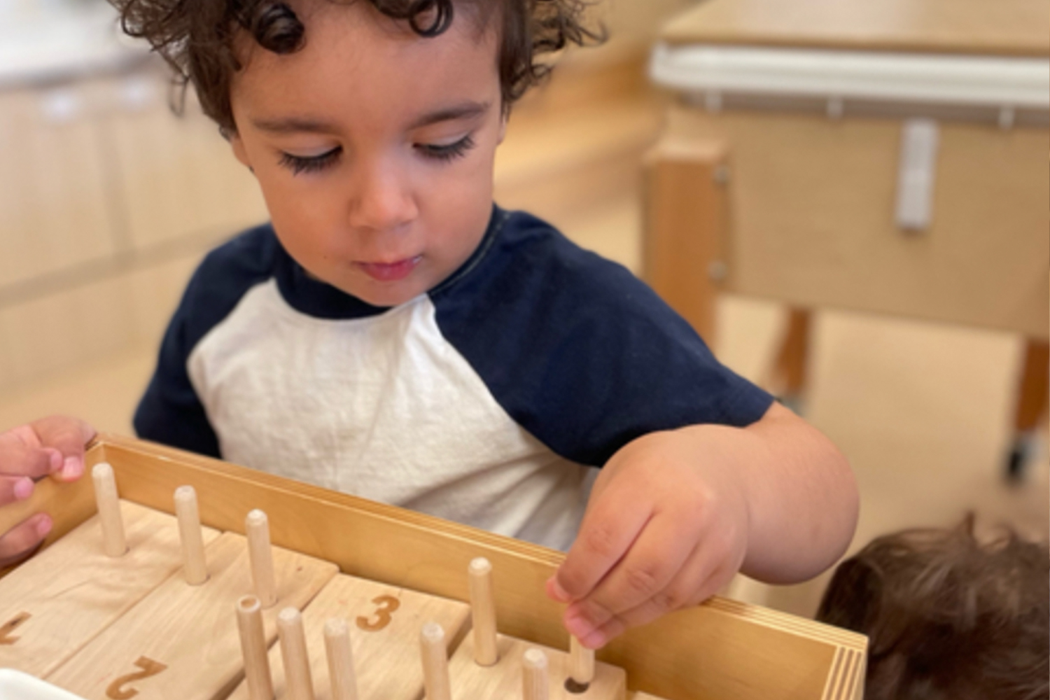 Student in Nursery 2s working on counting activity at Battery Park Montessori