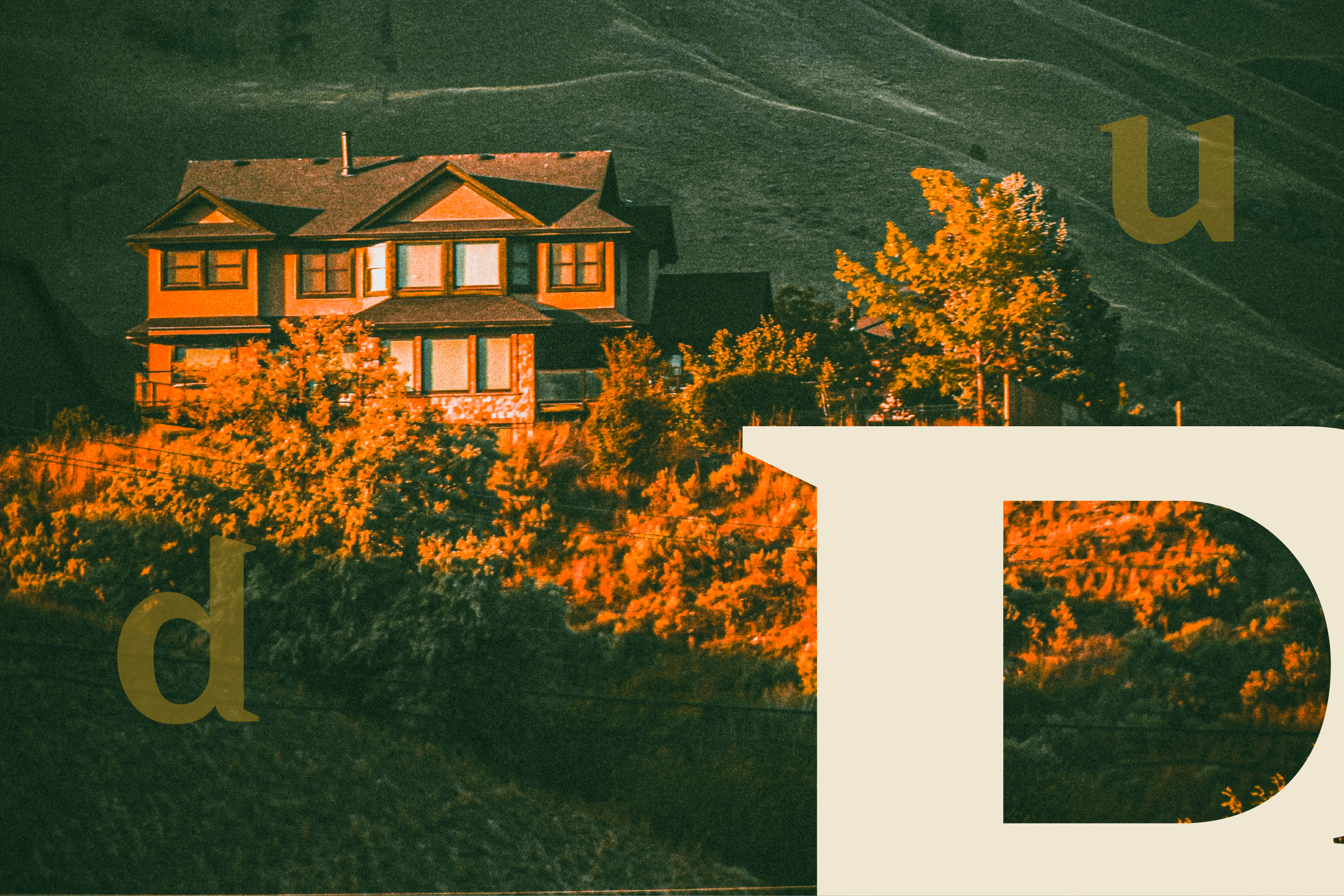 A multi-story house on a hillside surrounded by orange autumn foliage.