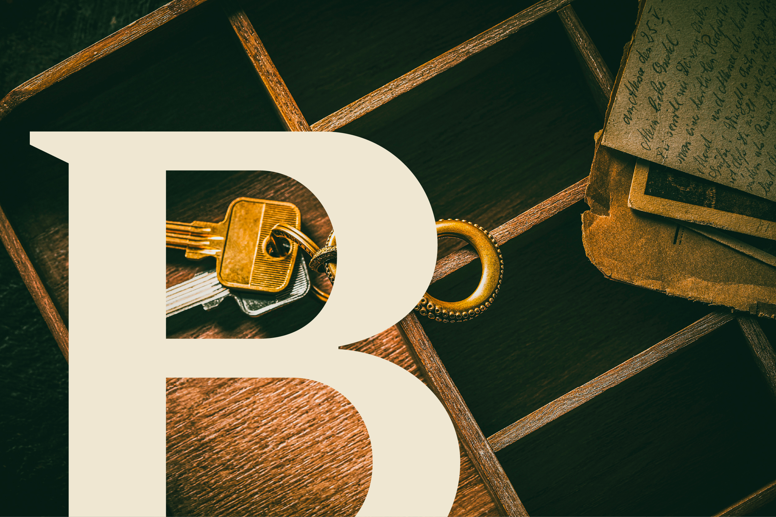 A set of keys and a keyring beside stacked handwritten letters on wood.