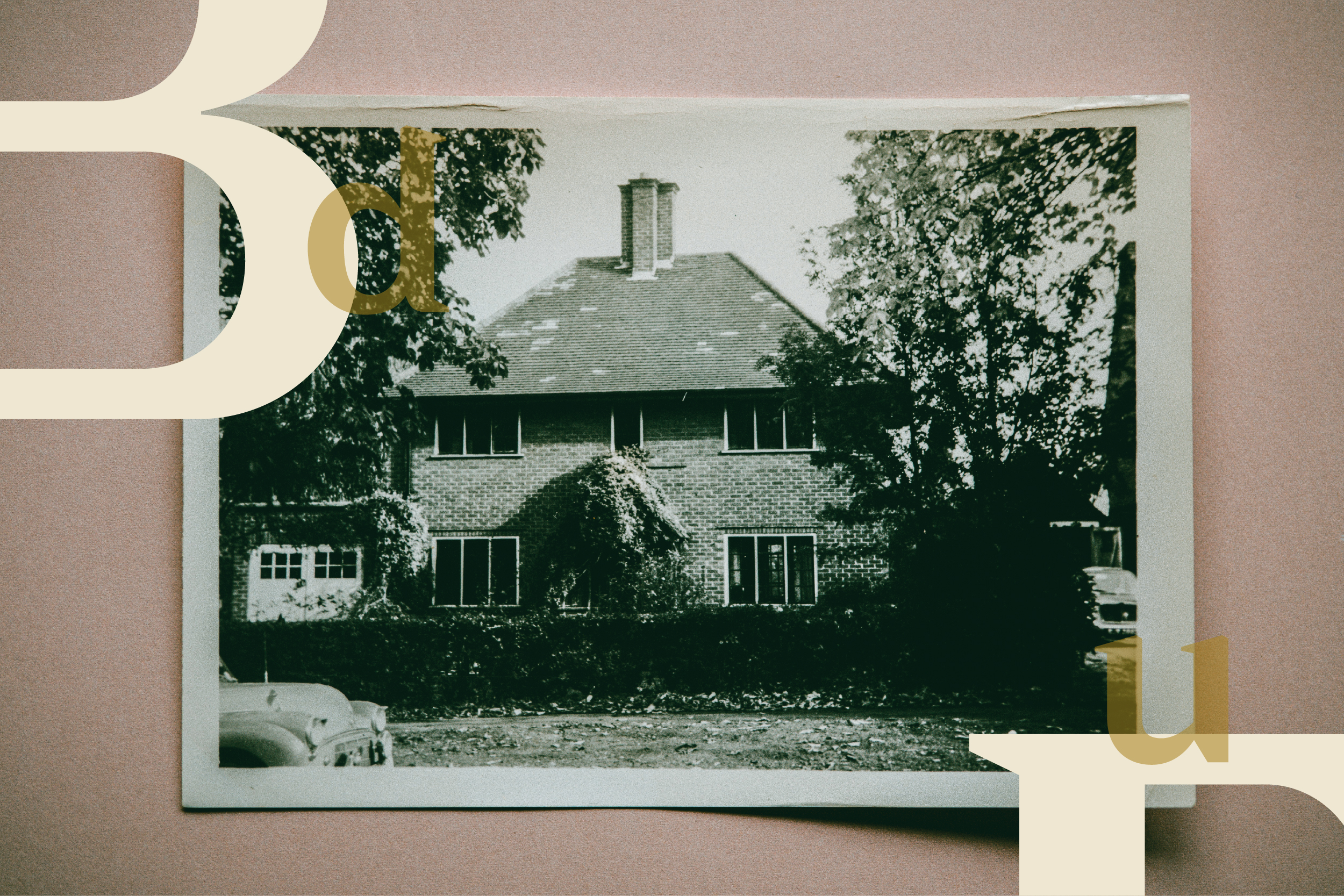 An old photograph of a brick house with ivy and trees.