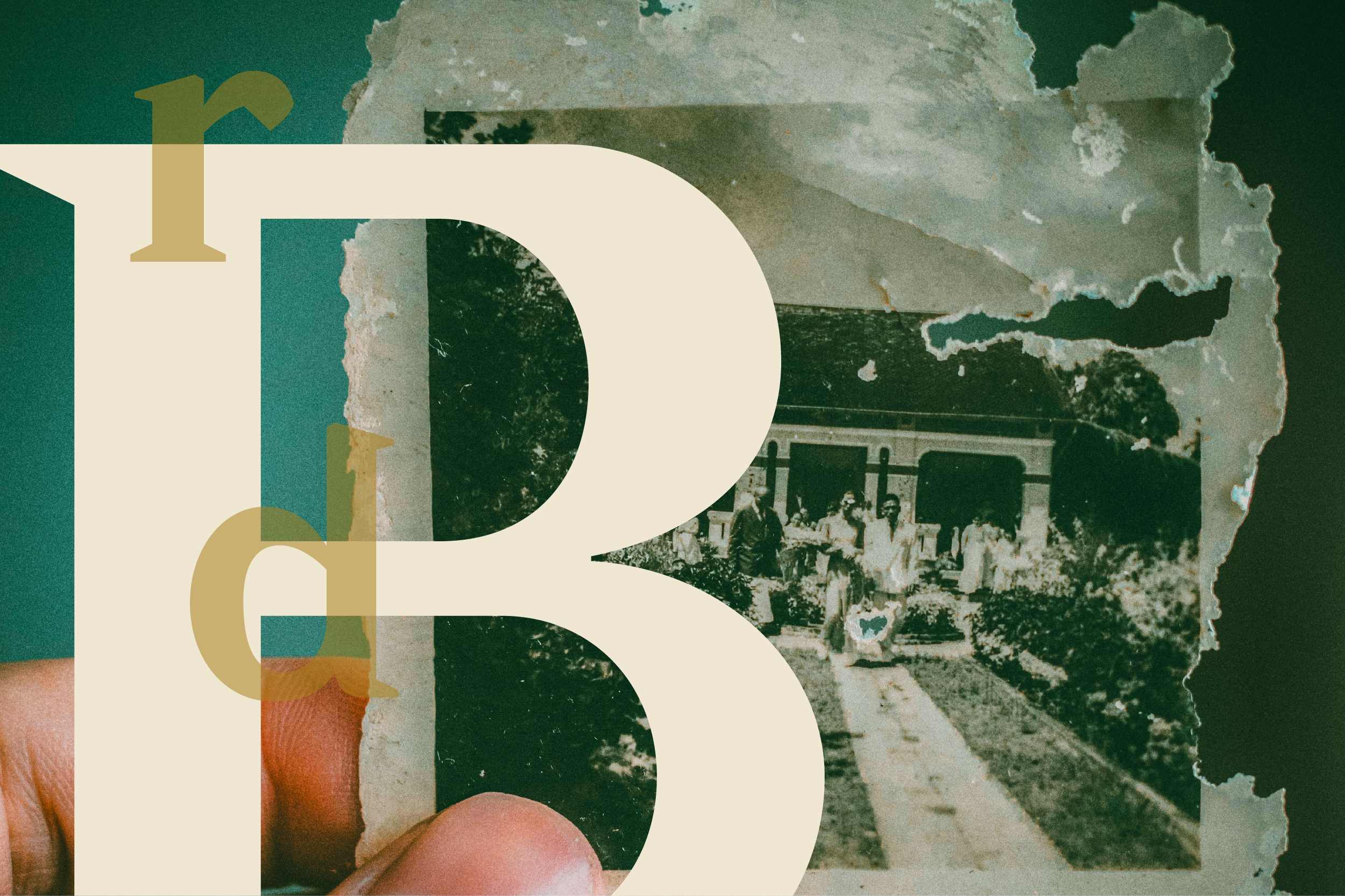 A hand holds a damaged antique photo of people outside a building.
