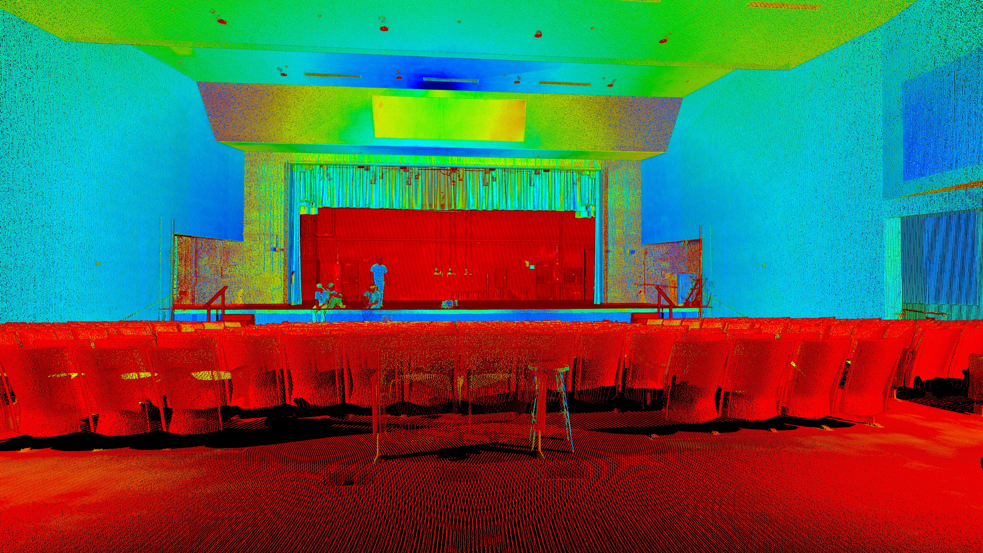 An audience watching a warmly lit school stage