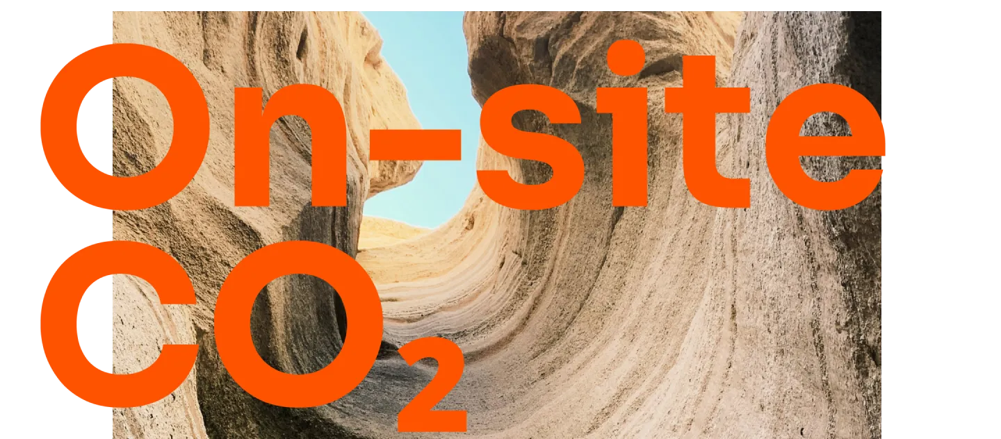 Narrow canyon walls in shades of tan and beige with a clear blue sky visible above, overlaid with large orange text reading 'On-site CO₂'.