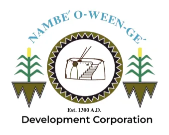 Logo of Nambe' O-Ween-Ge' Development Corporation featuring a central circular emblem with a traditional pueblo structure, flanked by stylized corn plants on both sides and the text 'Est. 1300 A.D.' below.