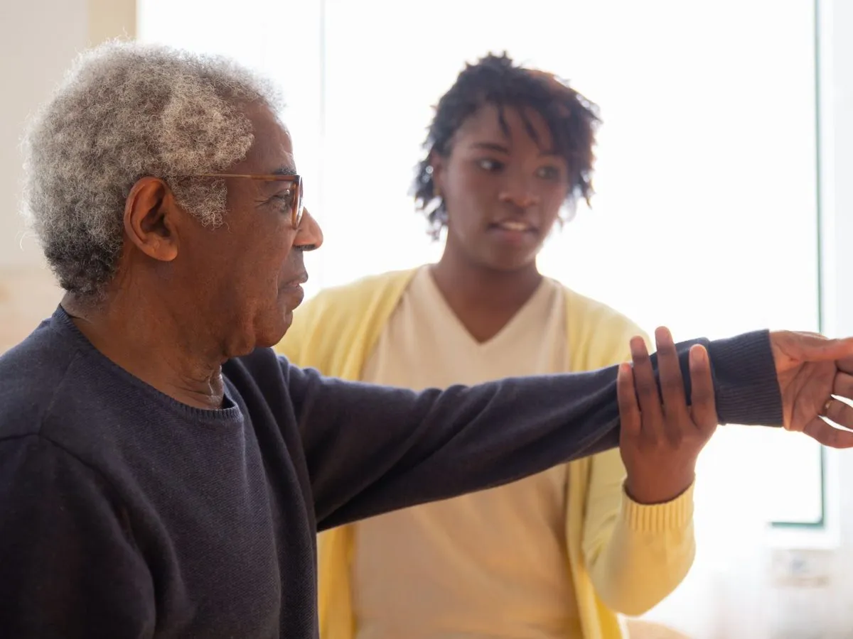 A caregiver assisting a patient with arm exercises