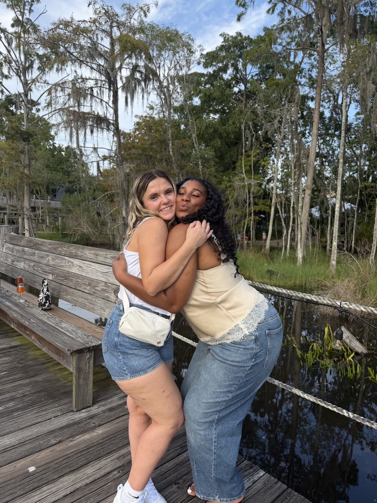 Two Access Home Health coworkers hugging on a dock at a team outing