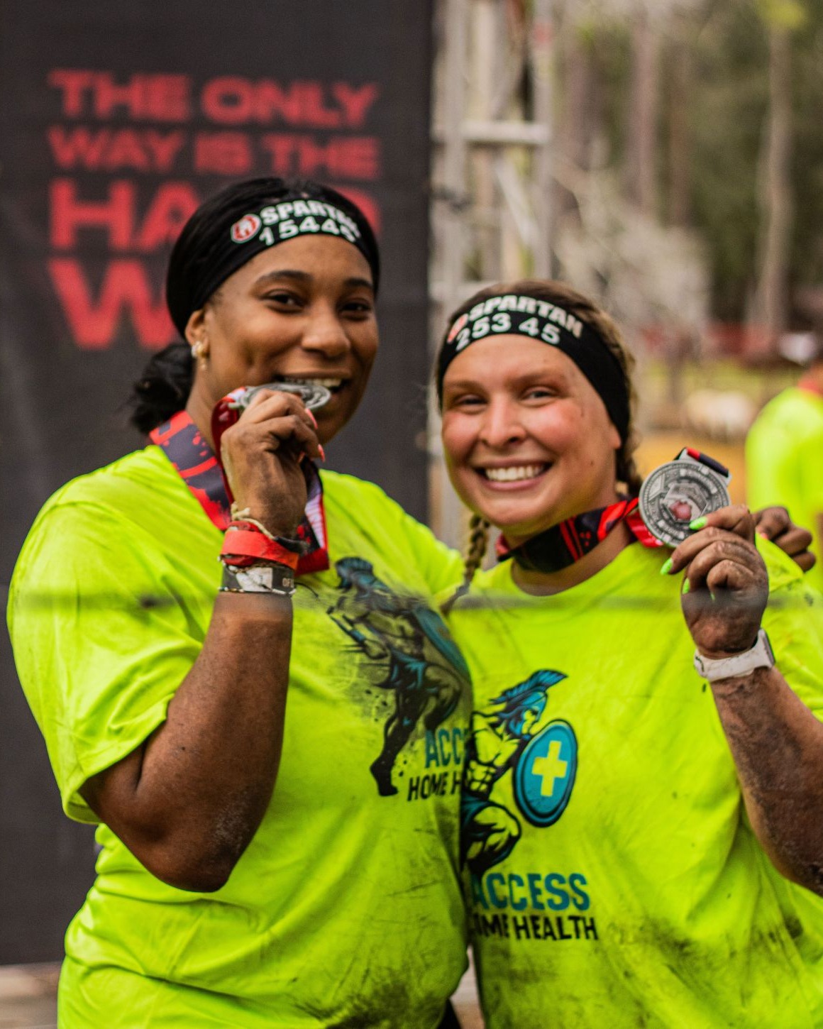 Two Access Home Health teammates showing their Spartan race medals