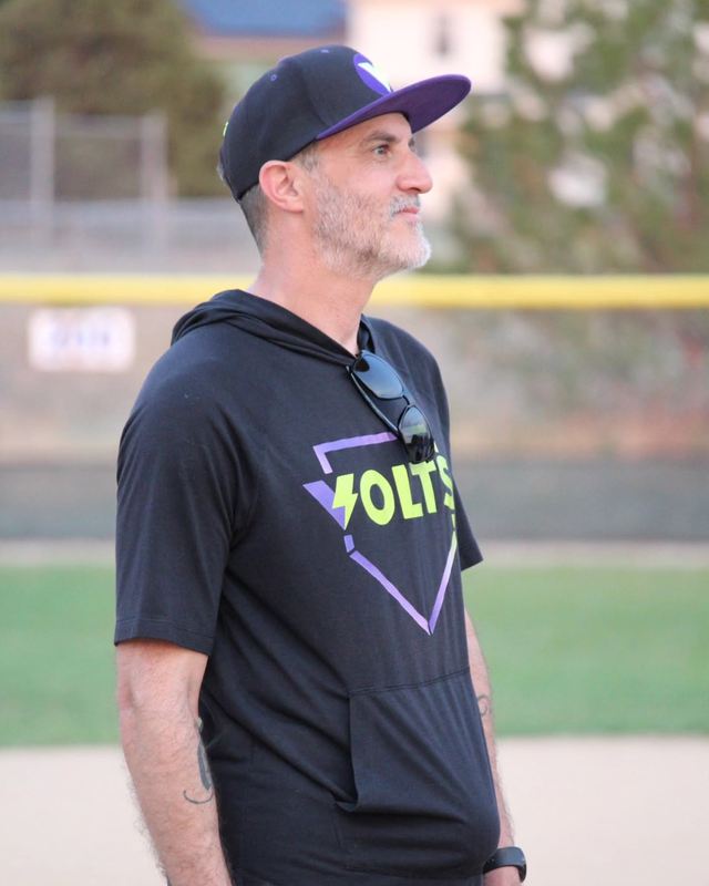 Jeff watching the field at dusk in a Volts hoodie