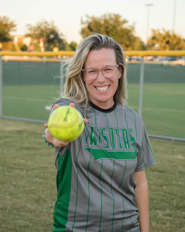 Kelly holding out a softball in a Twisters jersey
