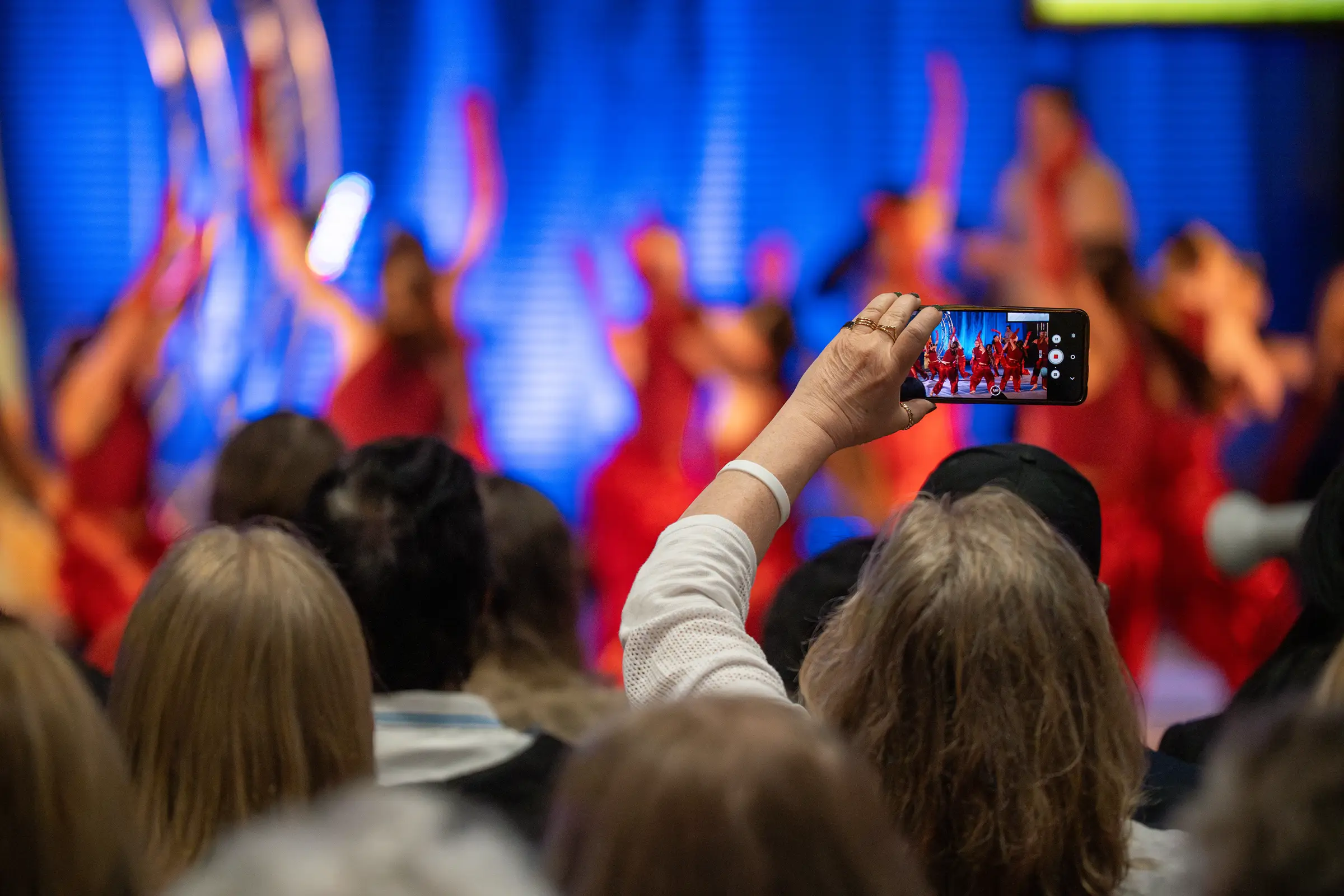 Une spectatrice filme la prestation d'une équipe au Championnat de danse Tempo 2026