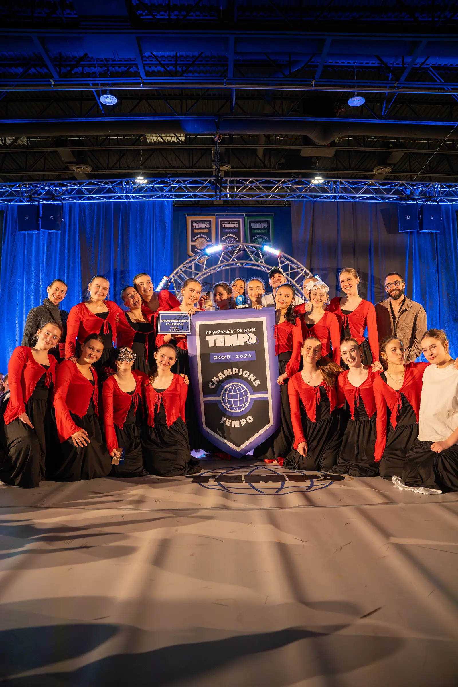 Une équipe championne pose avec sa bannière au Championnat de danse Tempo 2026