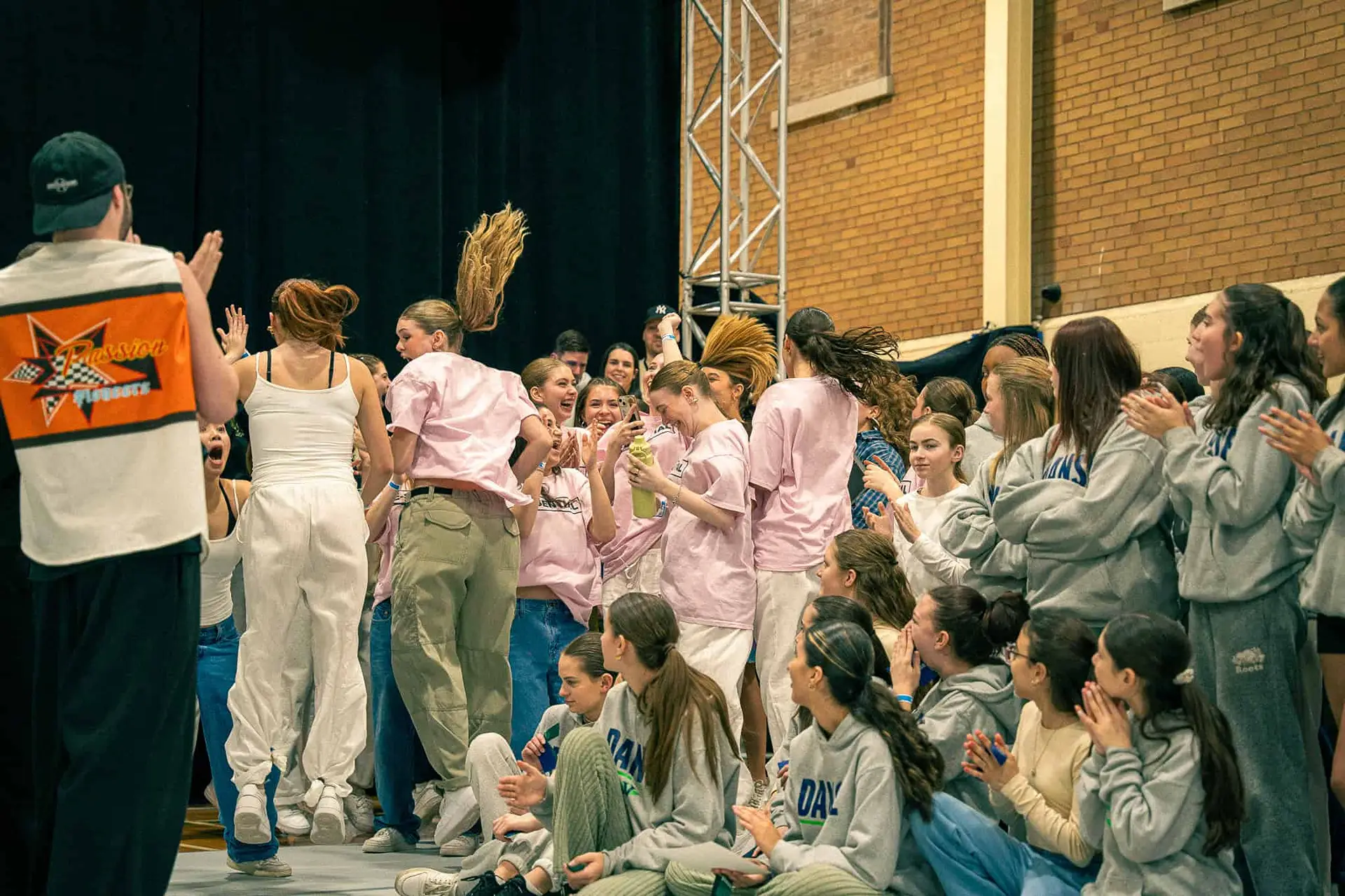 Une équipe en rose célèbre sa prestation entourée des autres danseurs, en 2024