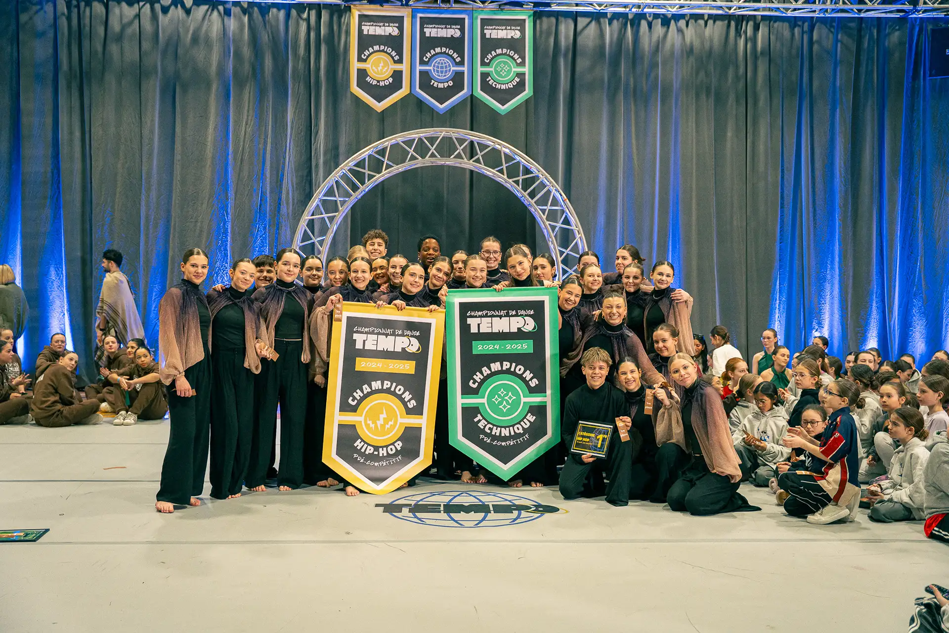 Les équipes championnes de la section pré-compétitive posent avec leurs bannières au Championnat de danse Tempo 2025