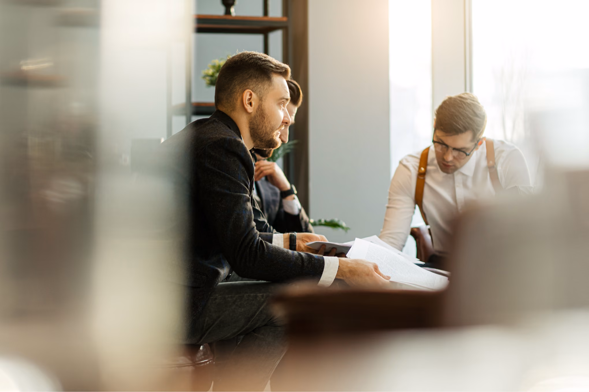 NINE Family Office team members reviewing documents during a business meeting in a bright office