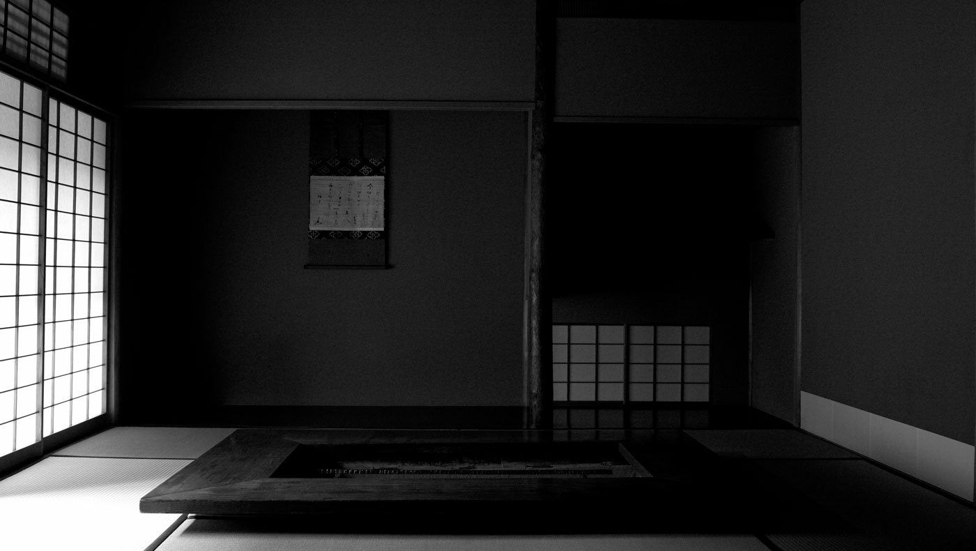 Black-and-white photograph of a tatami room at Kodaiji Wakuden, with a sunken hearth, shoji screens and an alcove.