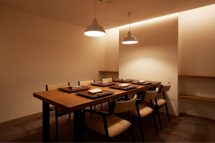 Private dining room at Myoujyaku with a table for six and pendant lighting.