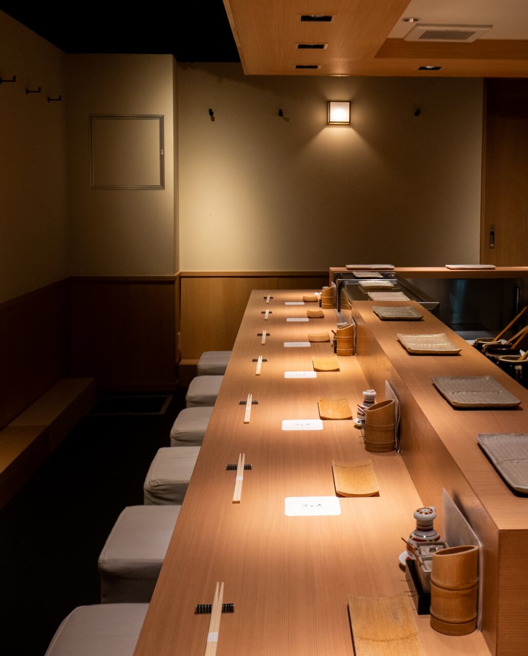 View along the Oshiage Yakitori Omino counter towards its central charcoal-grilling work station.