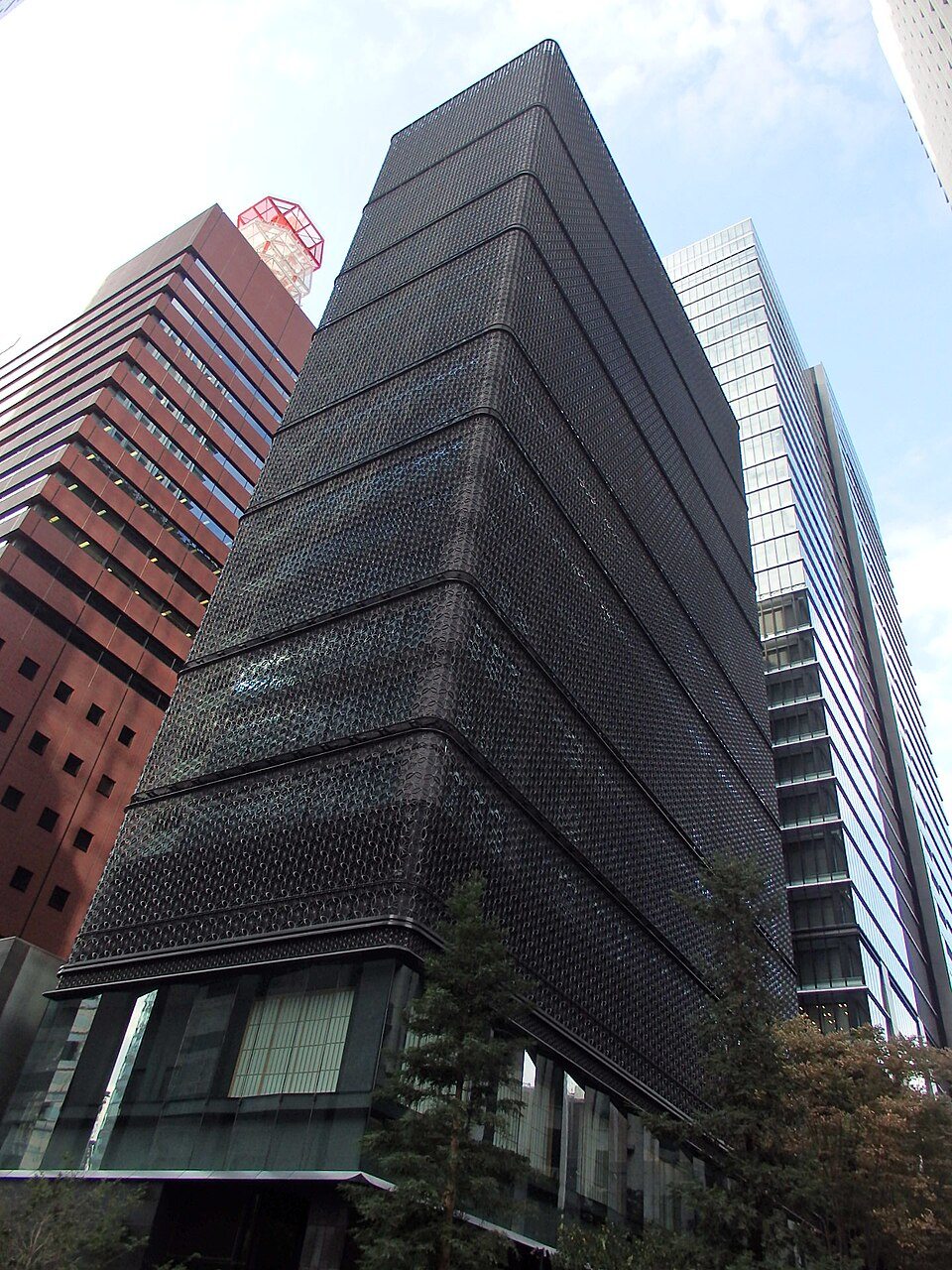 The dark patterned façade of HOSHINOYA Tokyo between neighbouring Otemachi towers, in an archival 2016 photograph.
