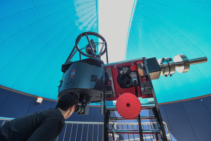 A visitor looking into an instrument in the main observing room at Yeongyang Firefly Astronomical Observatory.