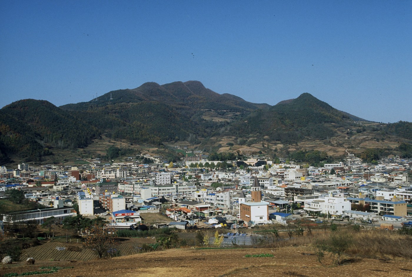 Archival panoramic view of Yeongyang-eup, with buildings, cultivated land and surrounding hills.