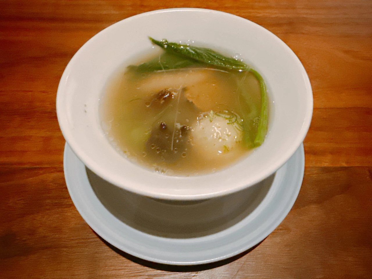 The Mingling Pot at Mingles: broth and several preparations served together in a white bowl, May 2025.