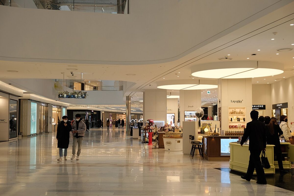Curving white balustrades and broad circulation around the ground-floor retail counters at The Hyundai Seoul in 2022.