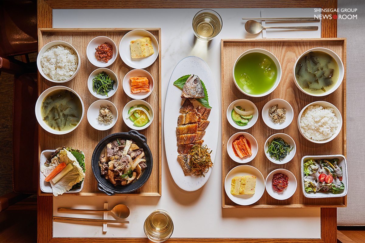An overhead operator photograph of rice, soup, side dishes, a beef dish and prepared croaker at Jaju Hansang.