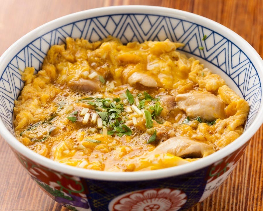 Bird Land’s chicken-and-egg rice bowl, with softly set yellow egg and green garnish.