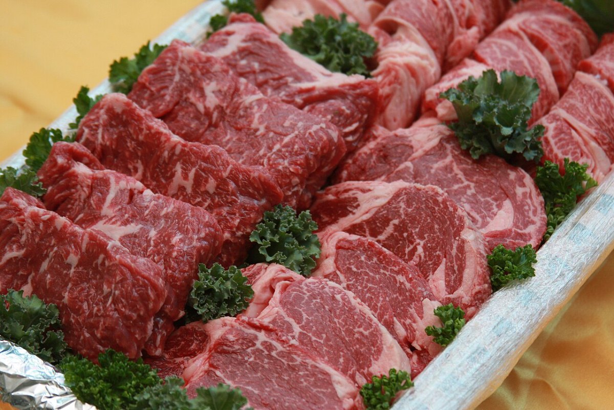 Raw, marbled Hanwoo beef from Seosan arranged in a tray with parsley.