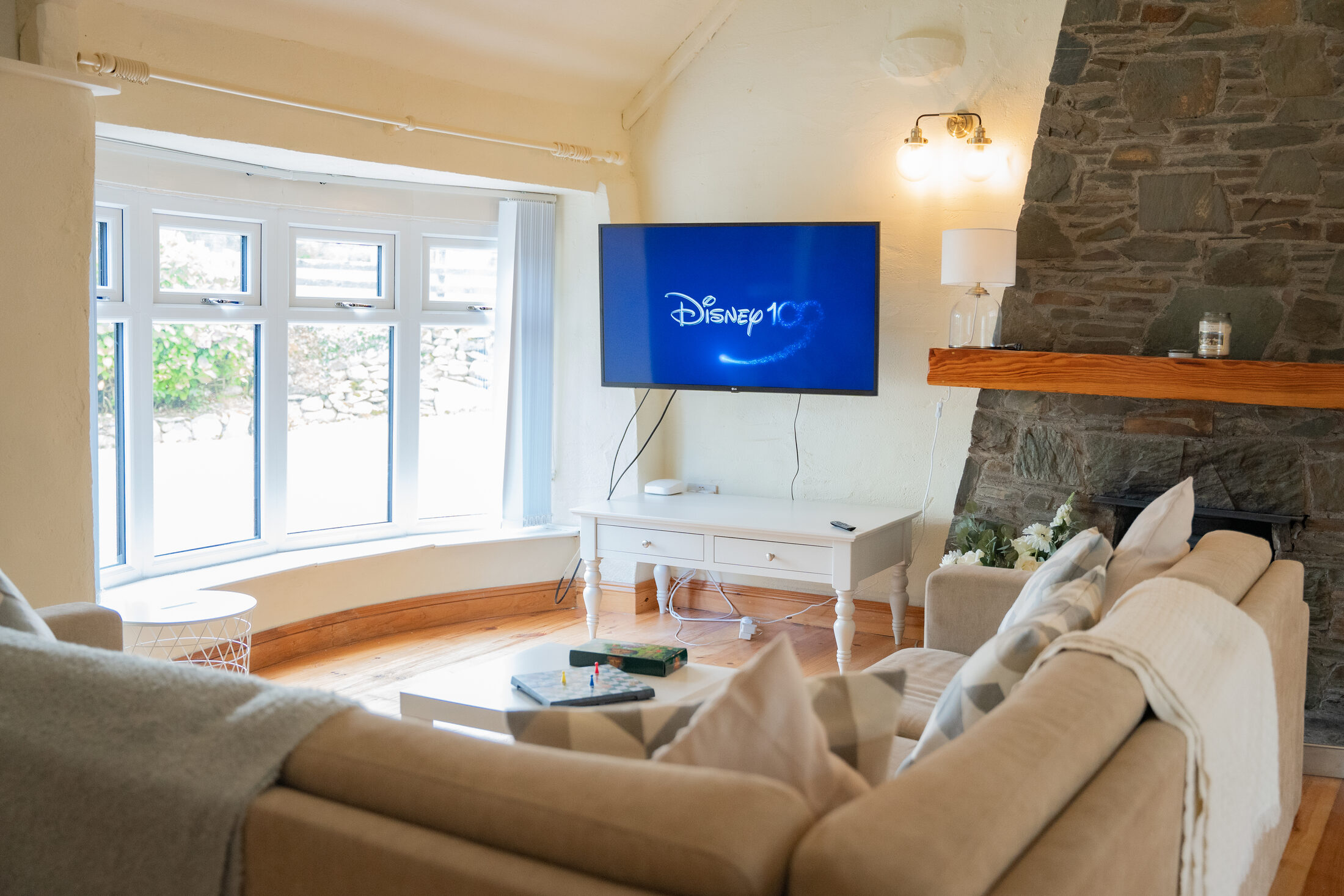 The cottage living room at The Briers, with a bay window and a corner sofa