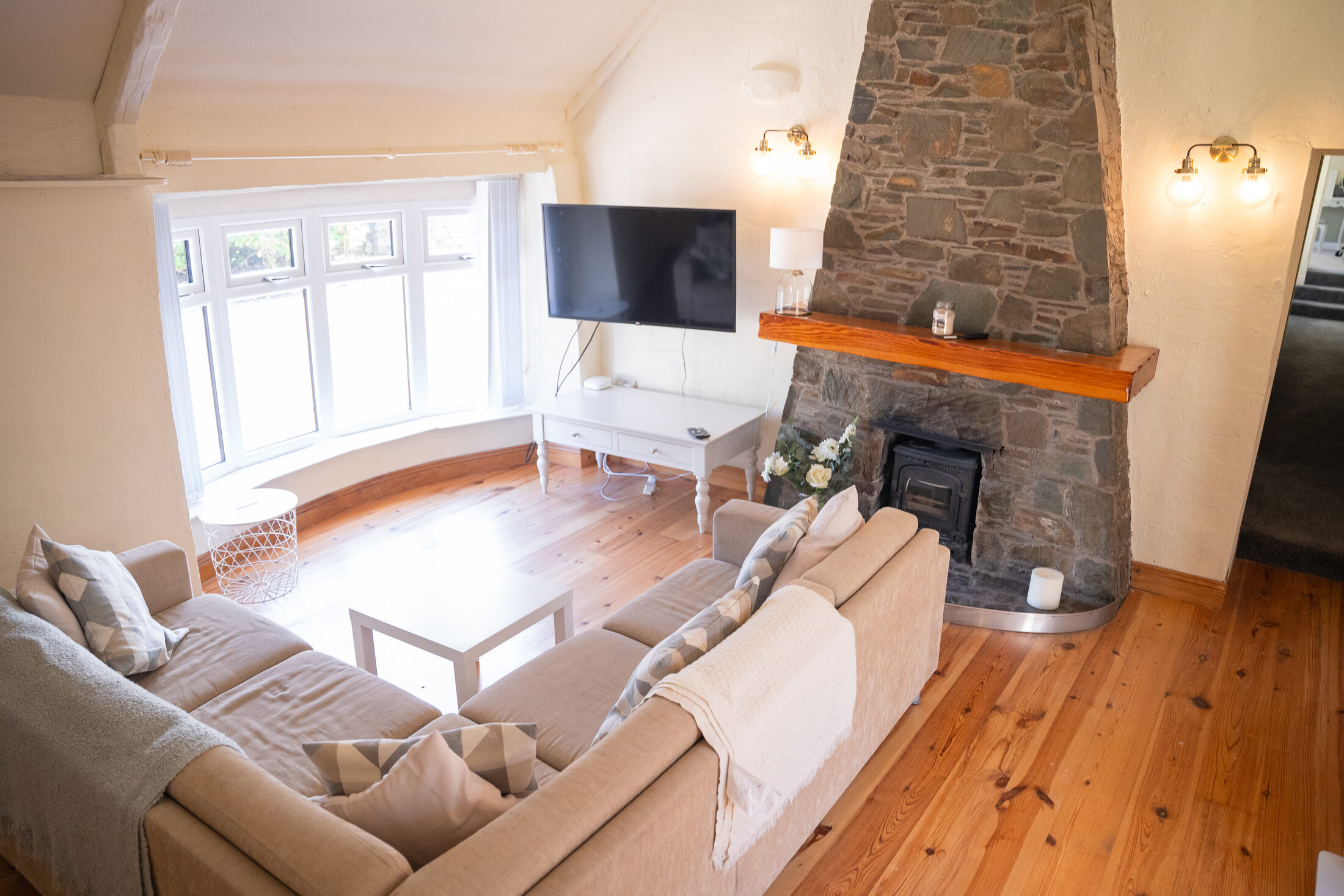 The cottage living room, looking towards the bay window and the stove