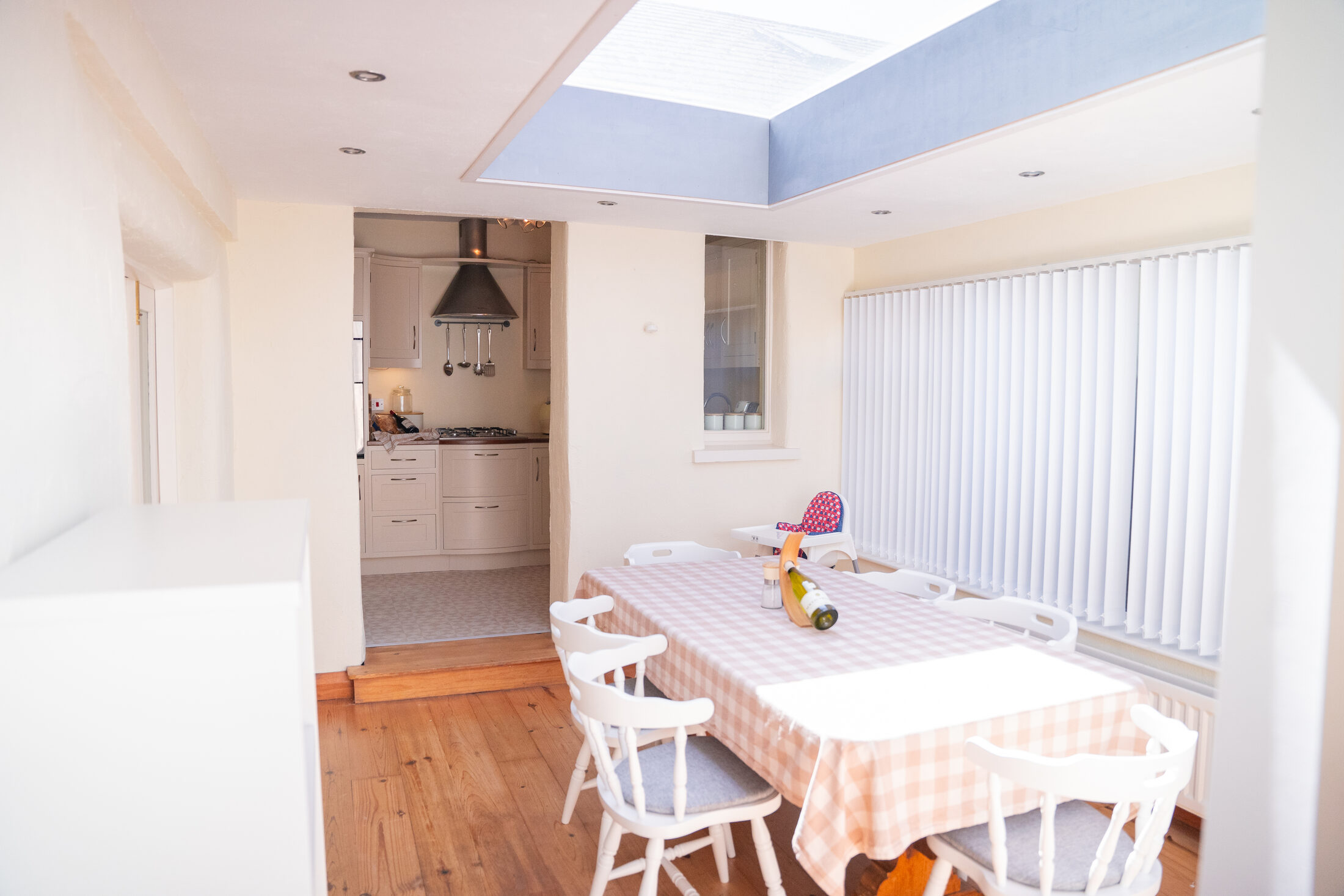 The dining room in the cottage at The Briers, lit by a skylight, with the kitchen beyond