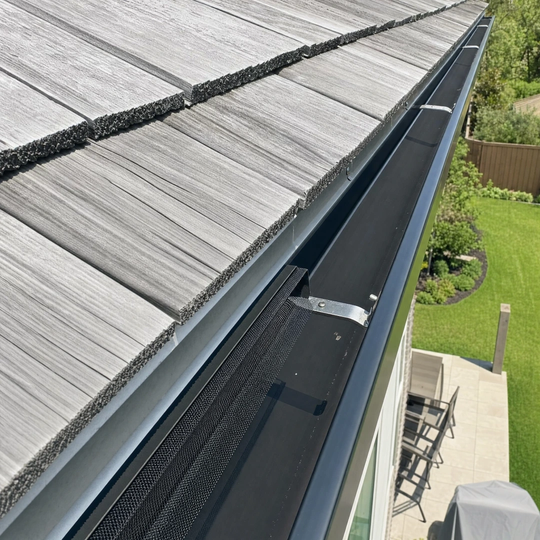 Leaf screen gutter guard being fitted over a K-style gutter to keep debris out of the trough