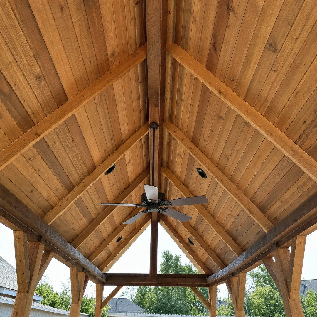 Patio cover under construction with rafters framed and stained tongue-and-groove ceiling boards going up