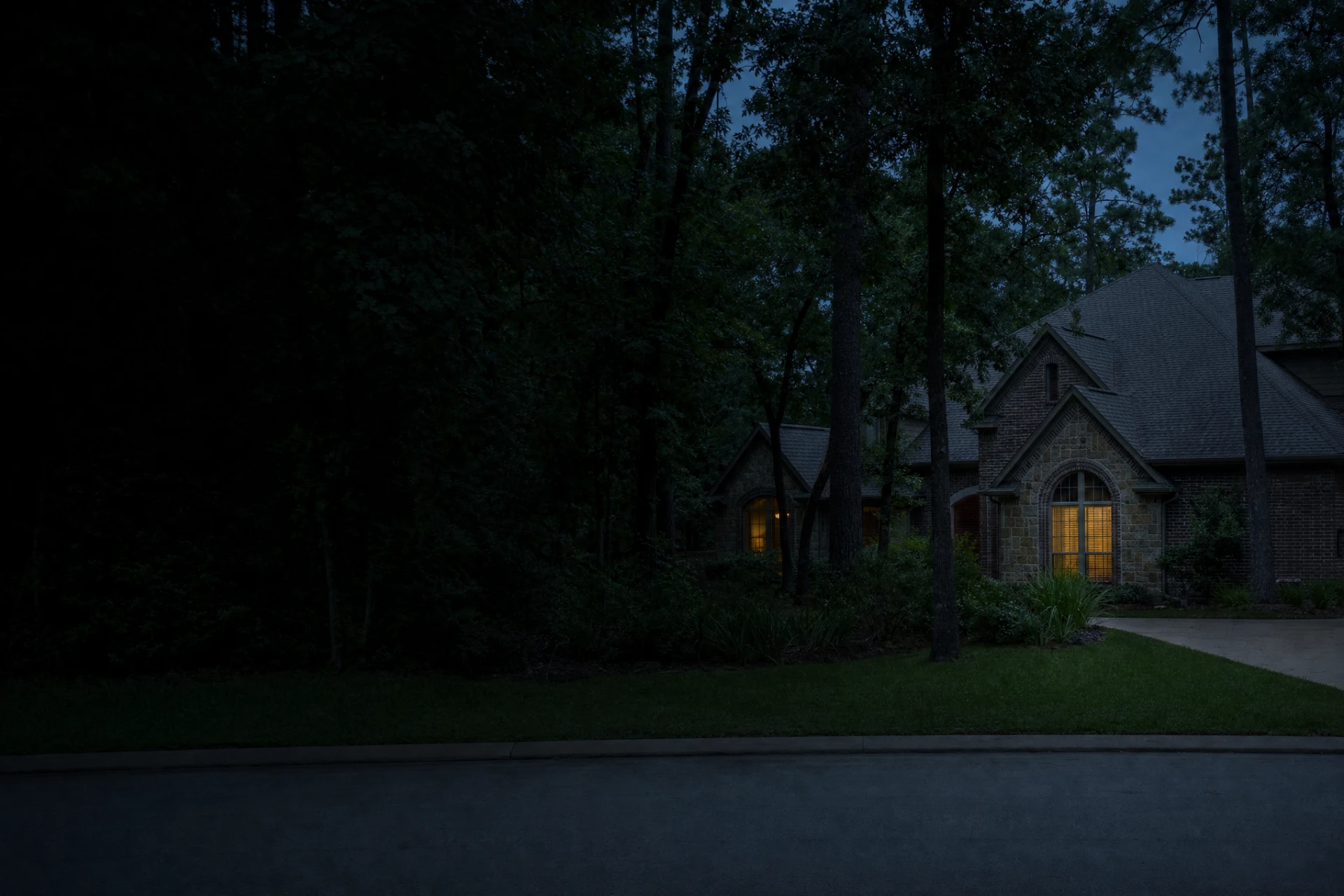 Home set among mature pines and hardwoods at dusk in The Woodlands, Texas