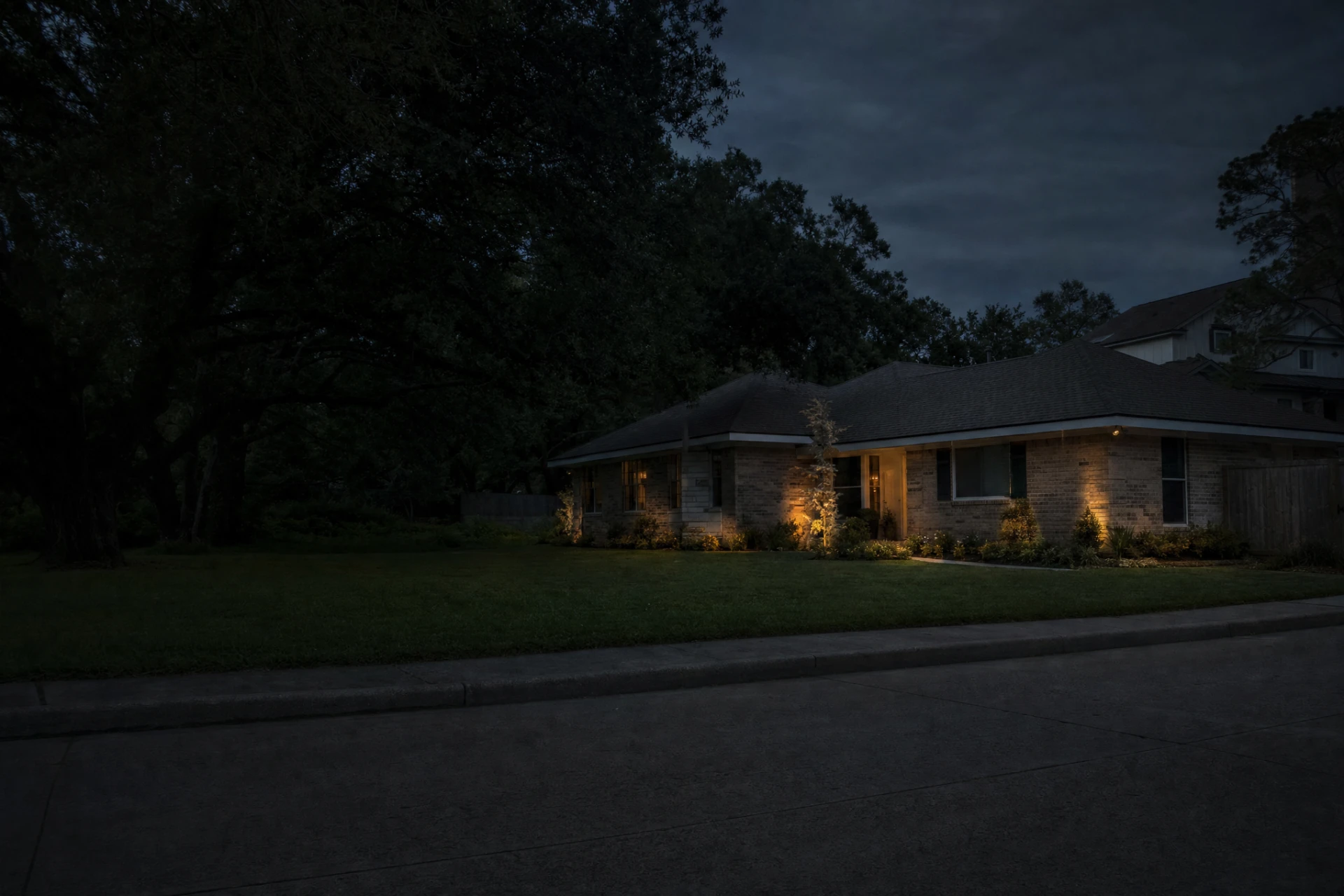 1950s brick ranch house on a large lot at dusk in Spring Branch, Houston