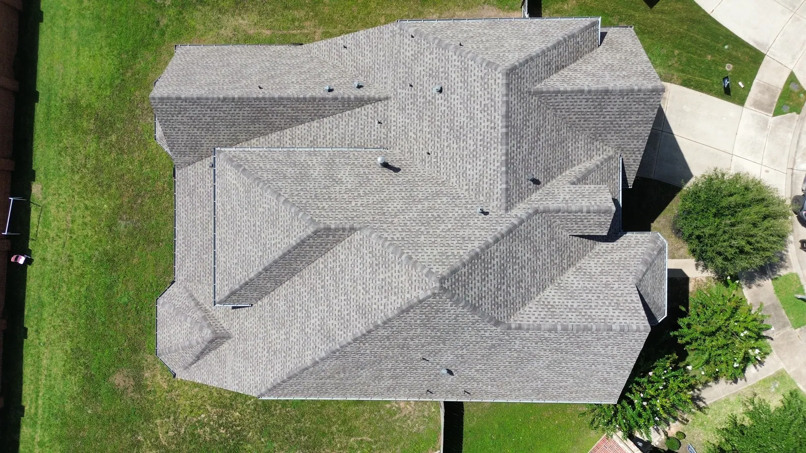 Drone view of a finished grey architectural shingle roof after a full replacement by AllPhase Contracting in Houston TX