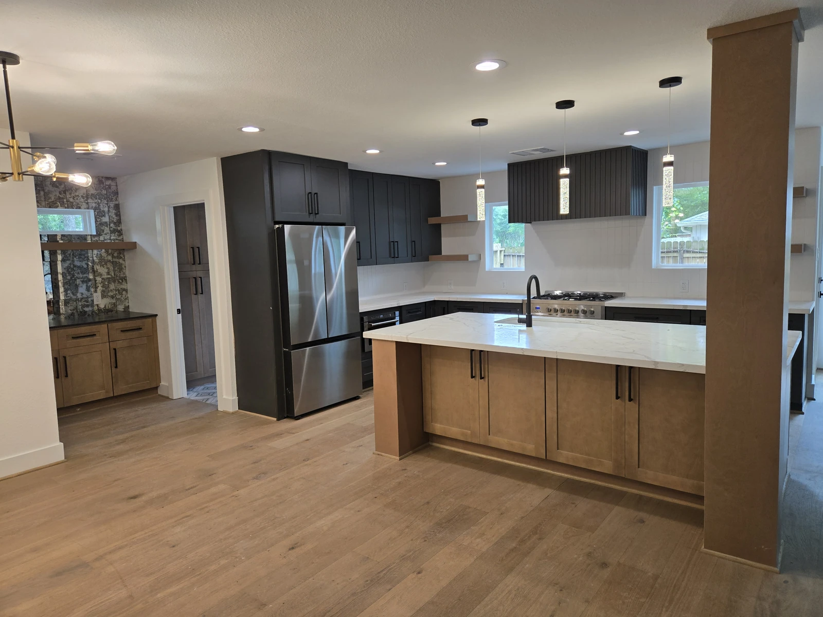 Open plan kitchen remodel with dark cabinets, a wood island and quartz counters in Houston TX