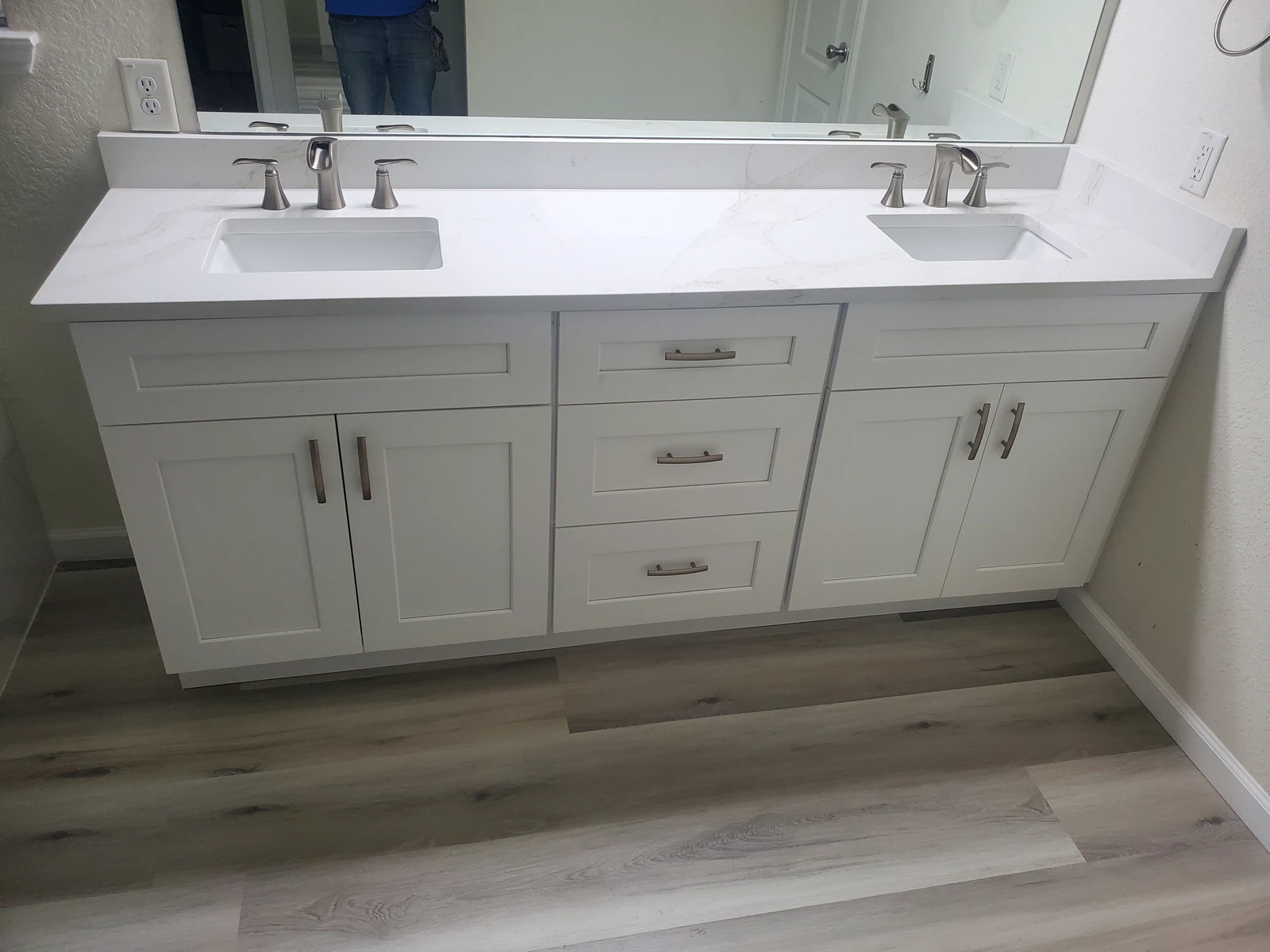Bathroom remodel with a white quartz double vanity and framed mirror in Houston TX
