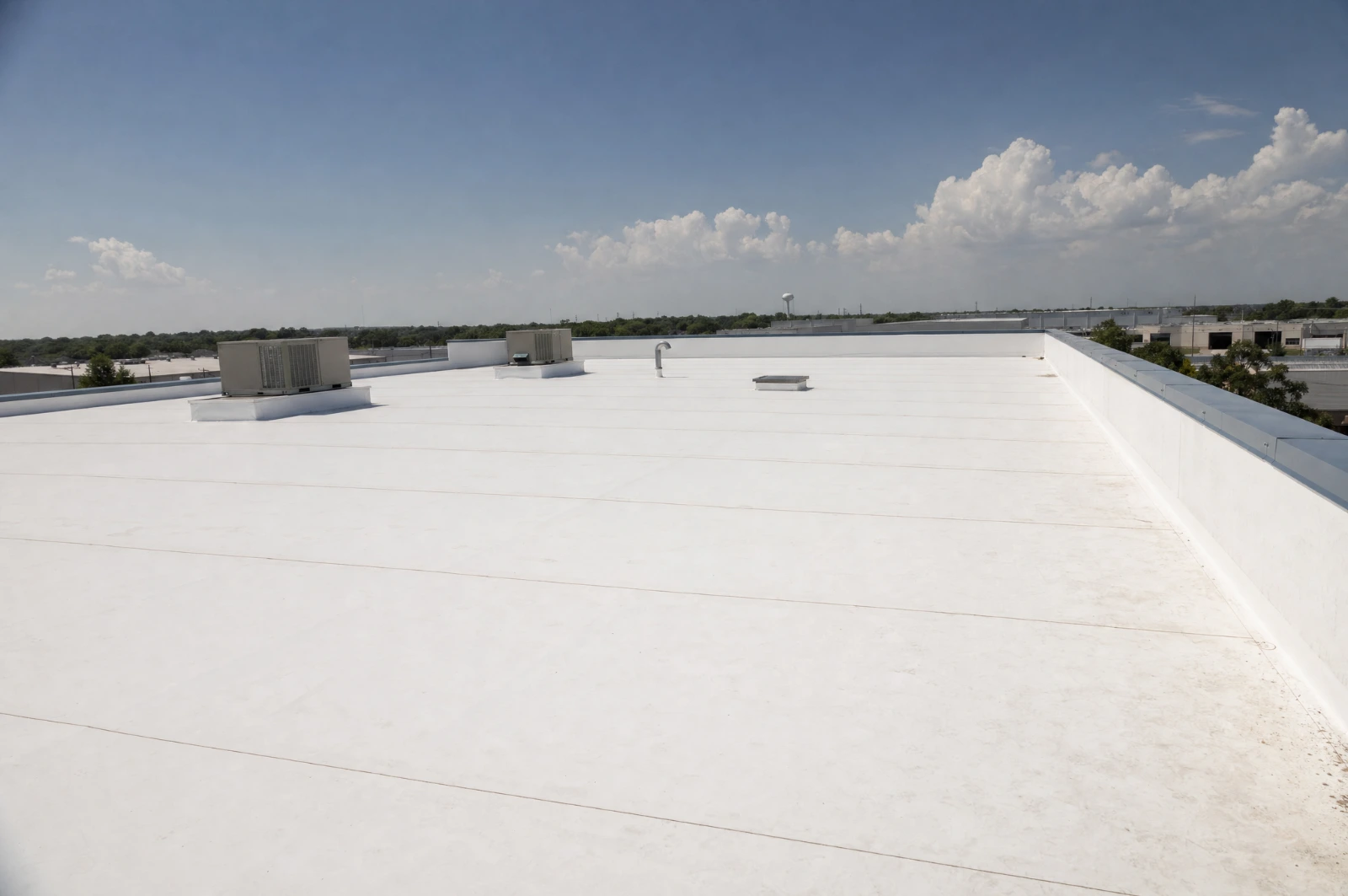 Completed white TPO roof with rooftop HVAC units on a Houston area commercial building