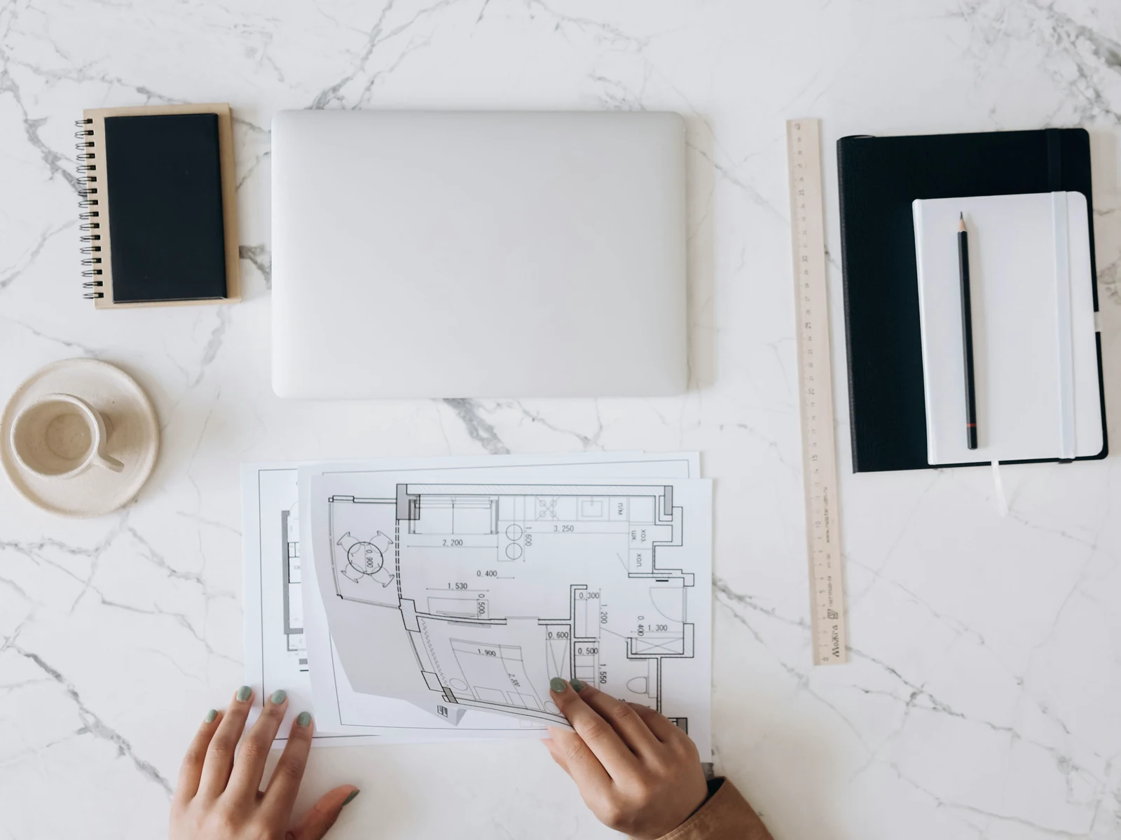 Website audit vs redesign: a blueprint spread out beside a laptop