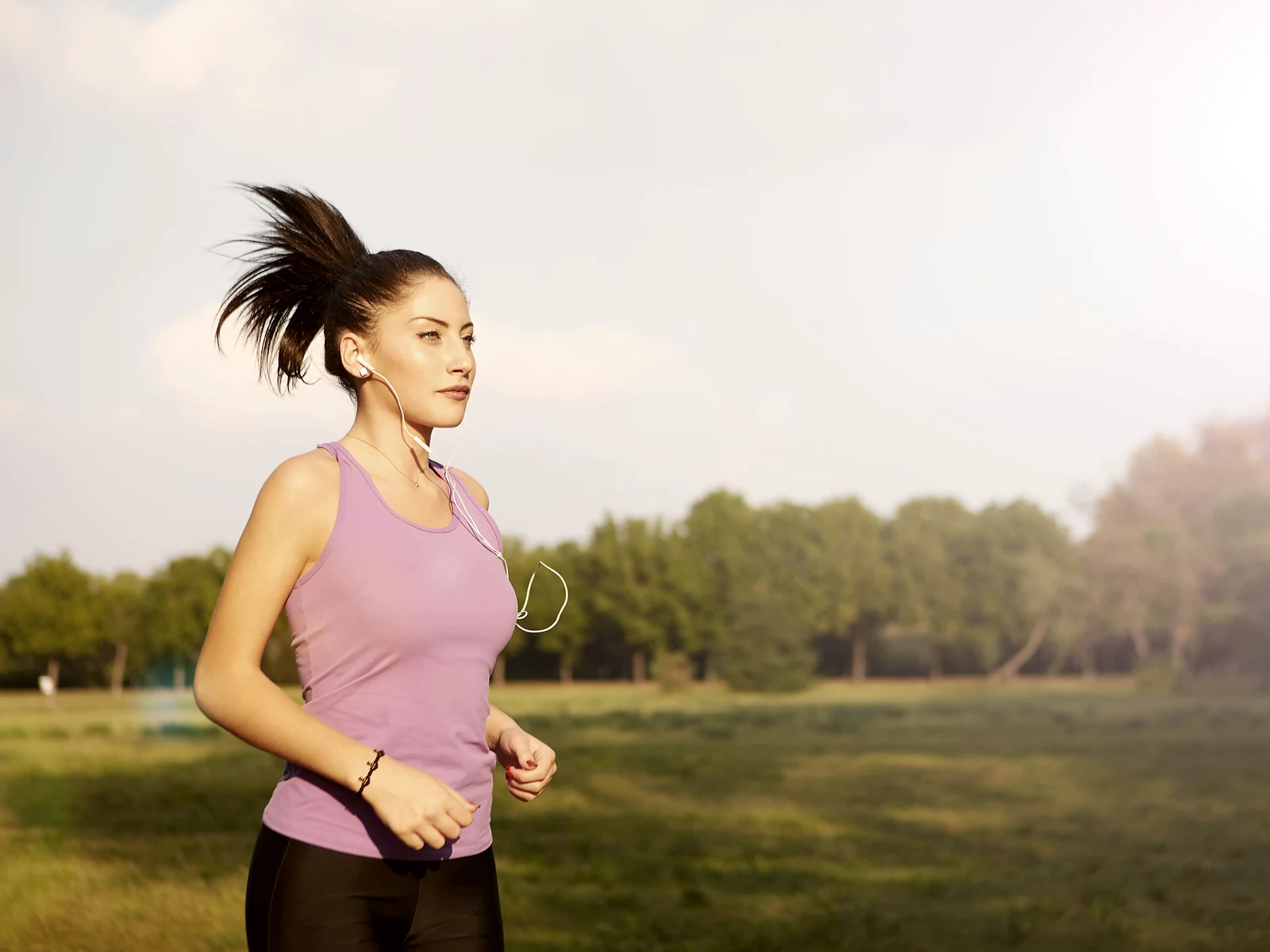 Content repurposing builds authority: a woman running steadily outdoors as part of her routine