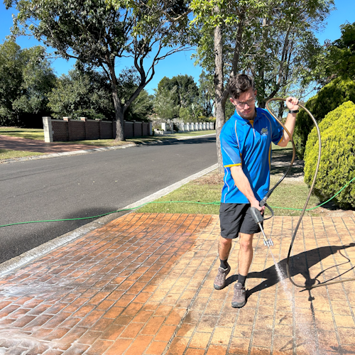 Posh Wash staff pressure cleaning a red brick driveway in Brisbane
