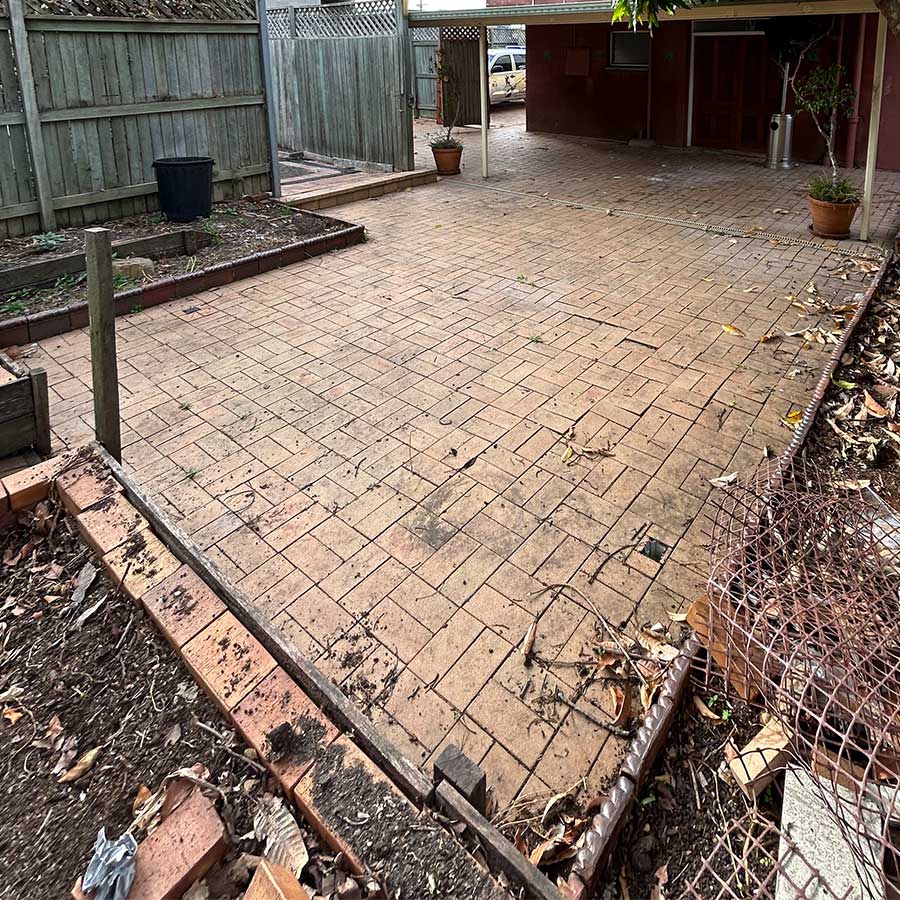 Laid brick paving covered in dirt and grime before cleaning