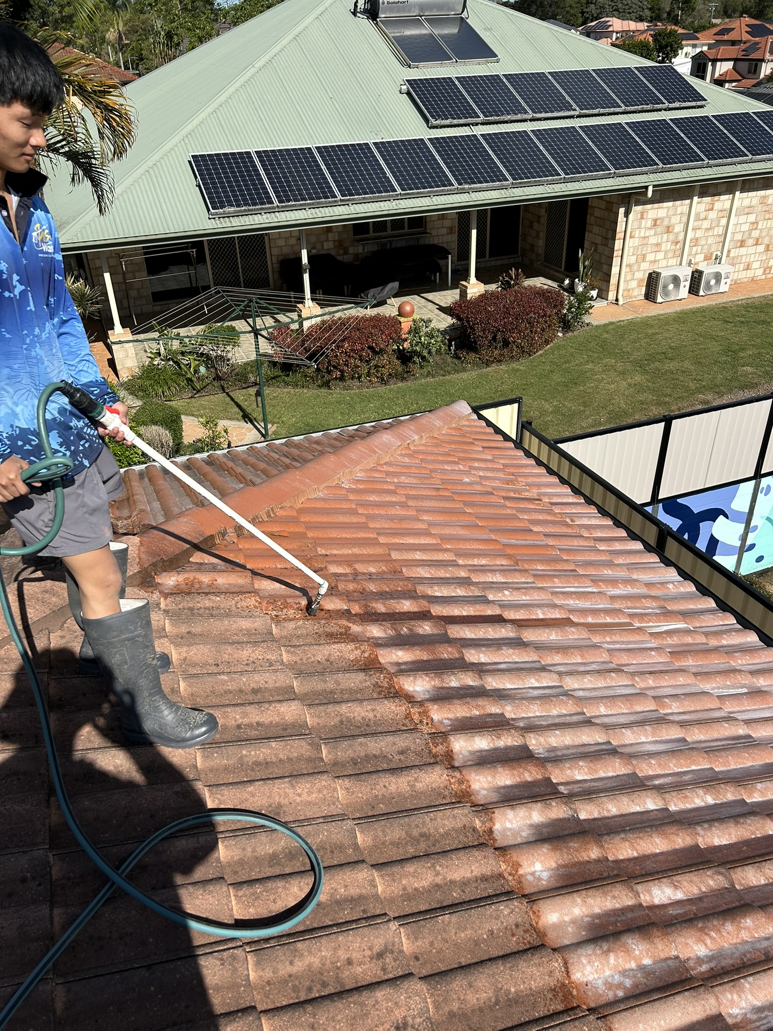 Soft washing a roof with chemical applied at low pressure