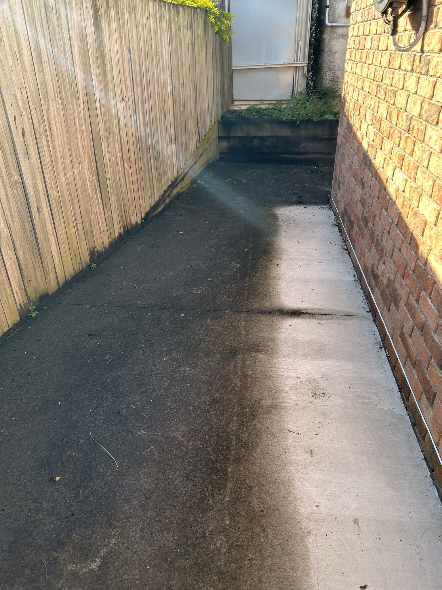 A stained concrete driveway before pressure cleaning