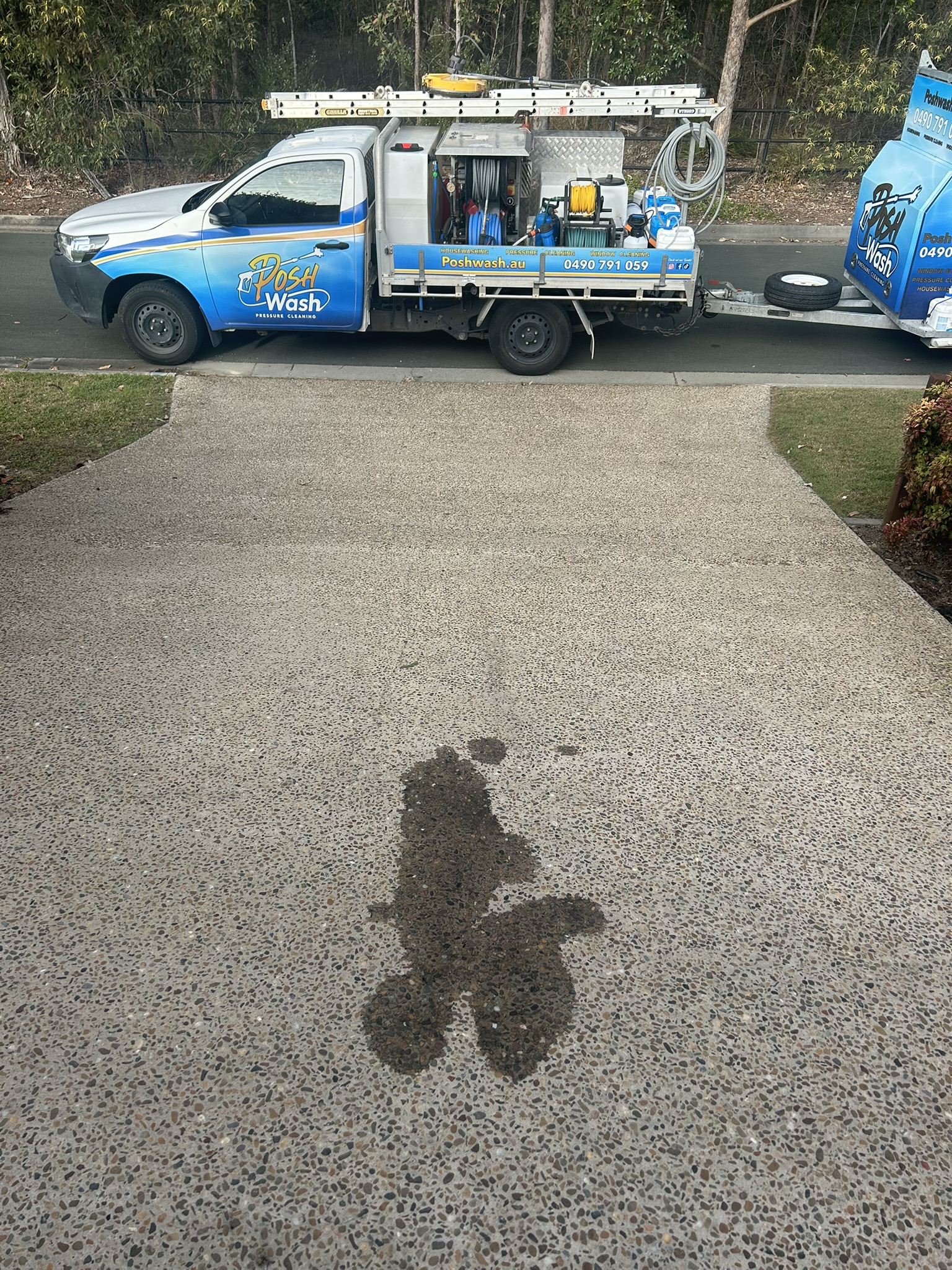 An oil stain soaked into a concrete driveway before treatment