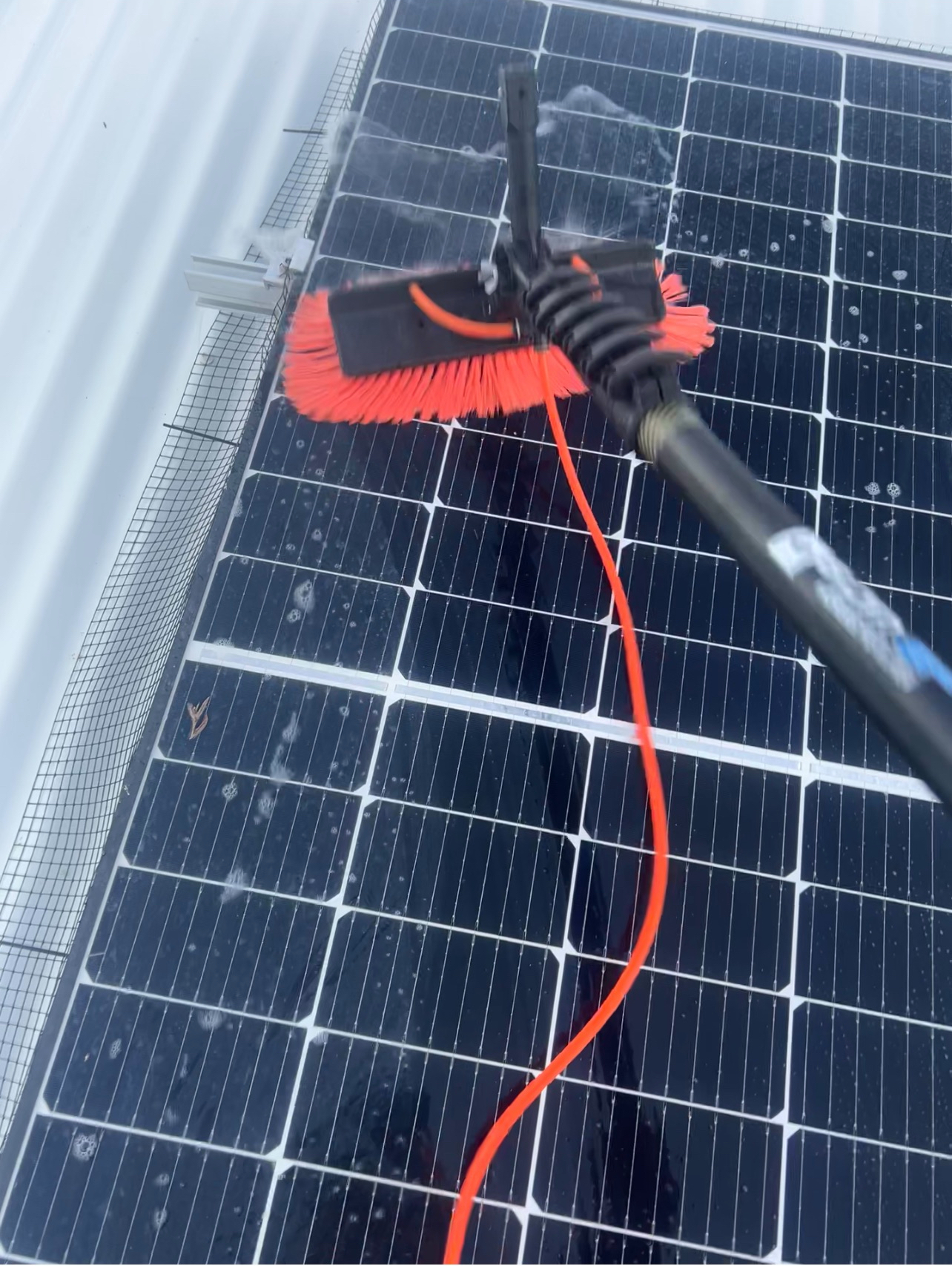 Solar panels being cleaned with deionised water on a Brisbane roof