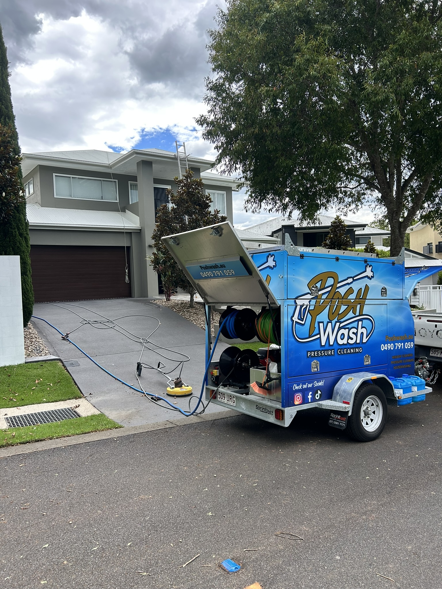 A house wash in progress on a Brisbane home, chemical being applied at low pressure